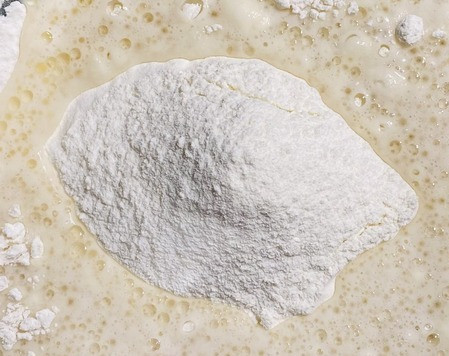 1. Этап. Ватрушки с творогом: Часть муки просеять в емкость в которой замешивать тесто, вылить дрожжевую смесь с яйцом и растительным маслом, перемешать лопаткой