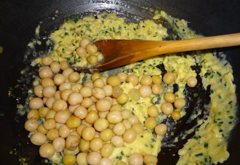 1. Этап. Бурый рис на сковороде: Далее всыпьте готовый горох. Перемешайте ингредиенты. Жарьте их вместе пару минут.