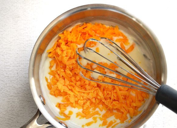 1. Этап. Сырный соус за 5 минут: 5. Снимите сотейник с огня и добавьте тертый сыр, перемешайте. Если сыр не расплавляется, верните сотейник на слабый огонь.