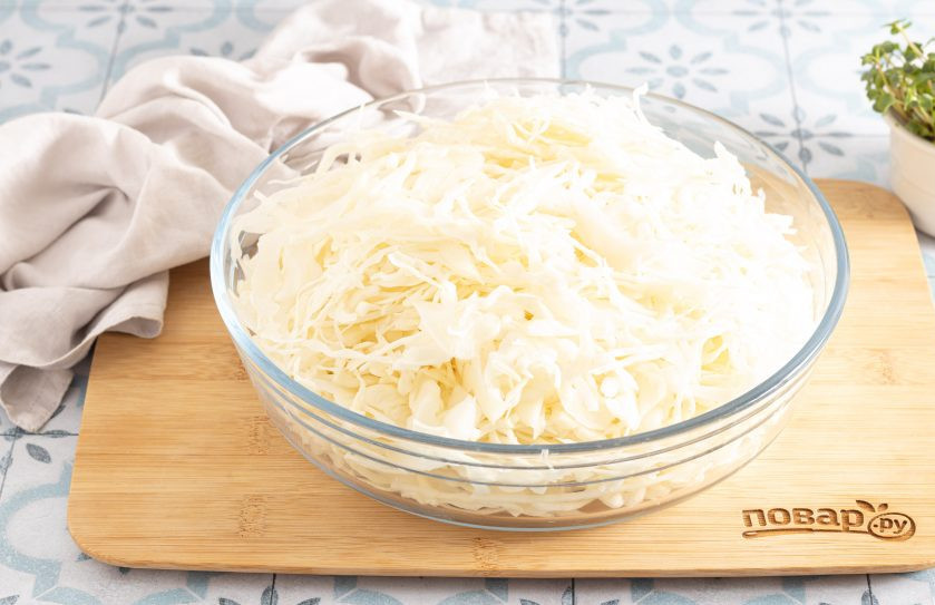 1. Этап. Квашеная капуста классическая в банке: Кочан капусты сполосните и снимите первые испорченные листья. Затем тонко нашинкуйте капусту.