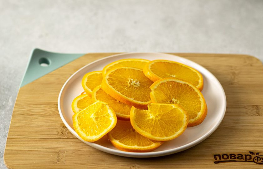 1. Этап. Цукаты из апельсинов: Помойте апельсины, после нарежьте на кружочки толщиной примерно 5 мм. Чтобы убрать горечь, залейте апельсины горячей водой на 10 минут. Воду слейте.