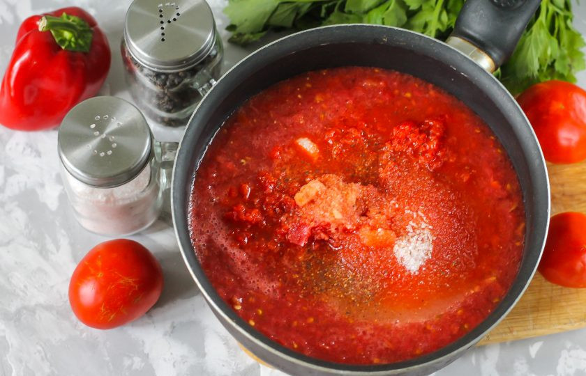 1. Этап. Заправка с перцем на зиму: Всыпьте соль, сахар, молотый черный перец. Спрессуйте очищенные и промытые зубчики чеснока. Поместите емкость на плиту и тушите примерно 30-40 минут, уваривая до необходимой густоты.