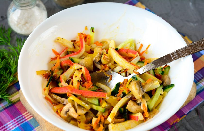 1. Этап. Салат с жареными крабовыми палочками: Салат перемешайте и добавьте специи: соль и перец. Масла больше на доливайте, ведь ингредиенты обжаривались вместе с ним. Заправлять чем-то дополнительно не нужно.