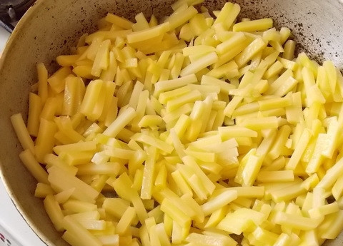 1. Этап. Картошка с сосисками в горшочках: 1. Картофель очистите и нарежьте тонкими ломтиками, небольшими порциями обжарьте на сковороде с разогретым растительным маслом. Посолите по вкусу, добавьте по желанию специи.