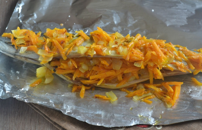 1. Этап. Запеченная скумбрия в фольге с морковкой: Нафаршируйте скумбрию пассированными овощами, сколько влезет, а остальное выложите сверху.