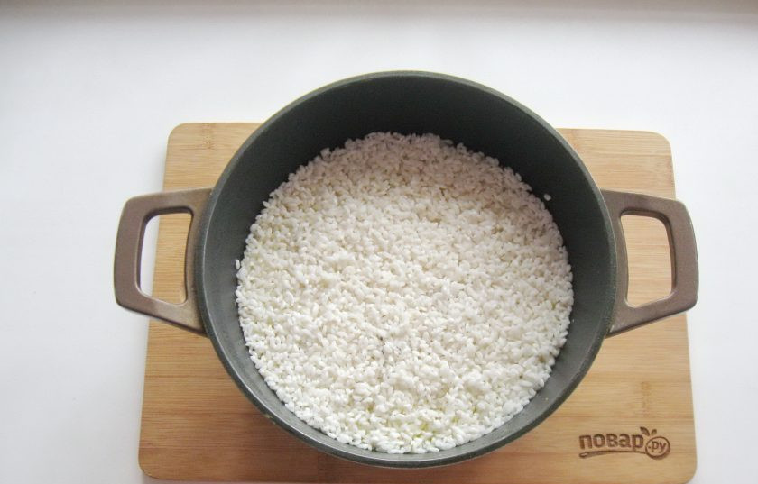 1. Этап. Туркменский плов: Выложите рис ровным слоем на курицу с морковью и луком. Немного посолите.