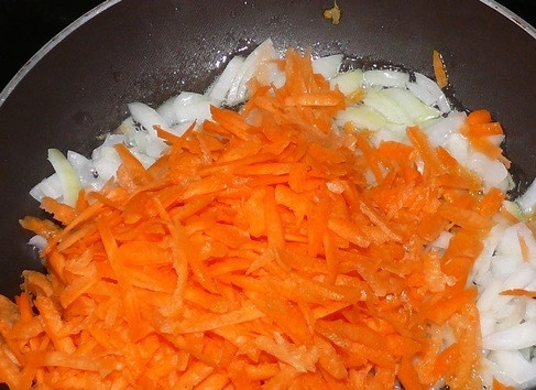 1. Этап. Вкусный борщ с тушенкой: 4. На сковороде с растительным маслом обжарьте измельченный лук до прозрачности. После добавьте тертую морковь и жарьте еще минут 5 на среднем огне, помешивая.