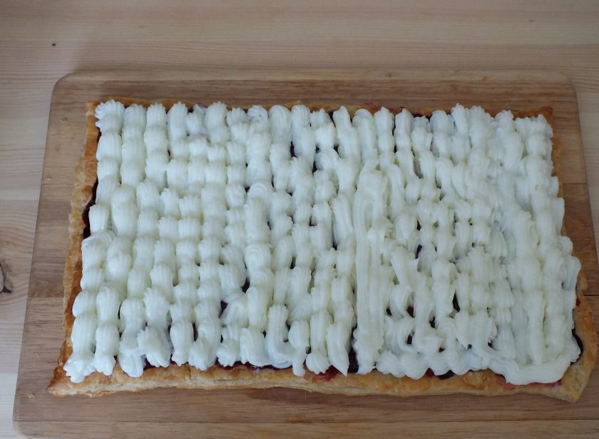 1. Этап. Пирожные с кремом и ягодами: Сверху, с помощью кондитерского мешка, нанесите крем.