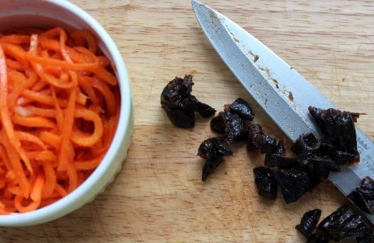1. Этап. Куриный салат с черносливом и грибами: 3. Измельчите чернослив и нарежьте морковь.
