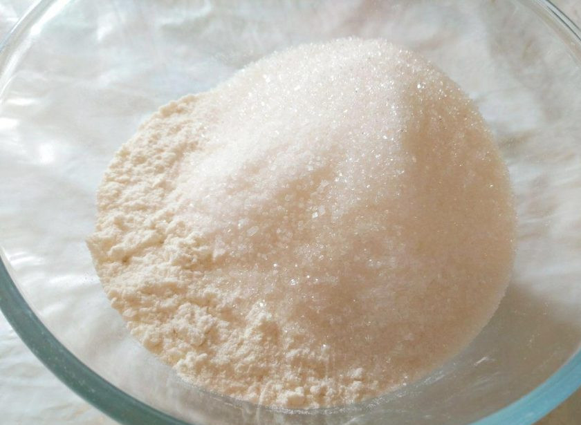 1. Этап. Сдобные булочки, прослоенные штрейзельной крошкой: Пока тесто поднимается, приготовьте штрейзельную крошку. Для этого соедините в глубокой миске оставшуюся просеянную белую муку (100 г), сахарный песок (150 г) и ванильный сахар.