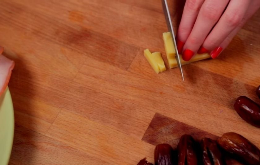 1. Этап. Финики в беконе (закуска): 1. Для начала очистите финики от косточек. Сыр нарежьте крупными кусочками и нафаршируйте им очищенные финики.