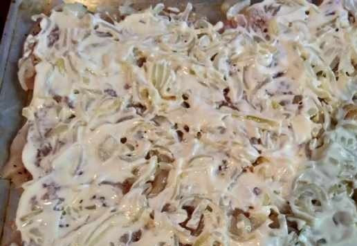 1. Этап. Курица запечённая с помидорами и сыром: Греческий йогурт смешать с горчицей и намазать сверху мясо с луком. Здесь можно использовать и нежирную сметану.