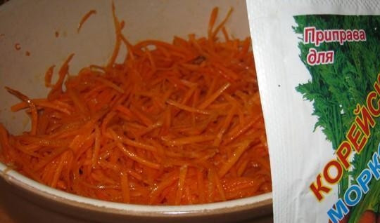 1. Этап. Свиные уши по-корейски: Морковь почистите, помойте, натрите на крупной тёрке. Лук почистите, мелко нашинкуйте и обжарьте в масле. Морковь залейте этим маслом. Перемешайте и оставьте на 5 минут под крышкой.
