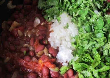 1. Этап. Тушеная красная фасоль: Промойте и нарубите кинзу, чеснок натрите на мелкой терке. Положите ингредиенты в сковородку. Блюдо посолите, поперчите, добавьте специи по вкусу и перемешайте.