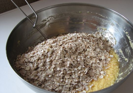 1. Этап. Печенье из овсяных хлопьев: Добавляем смесь хлопьев с мукой в масляно-яичную смесь.
