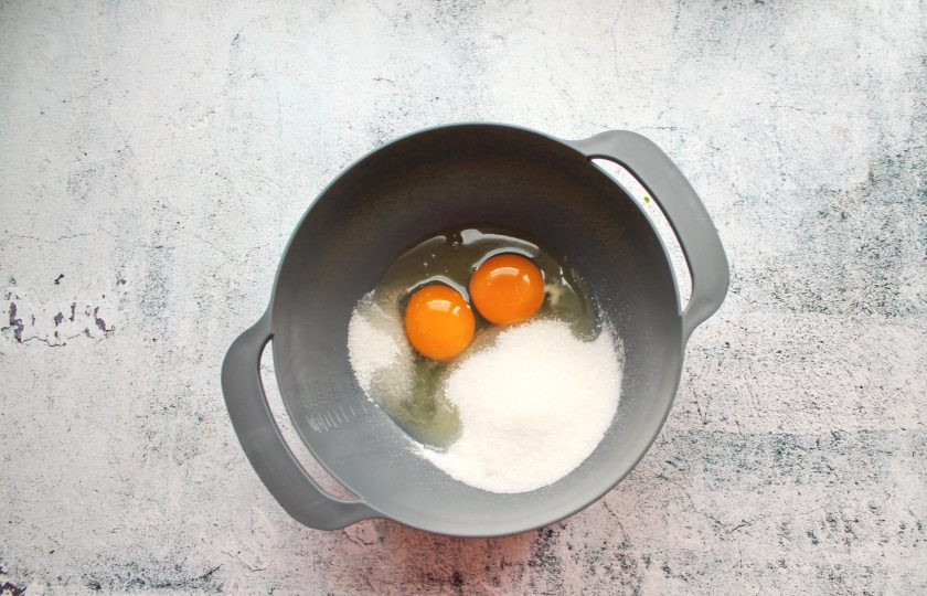 1. Этап. Бисквитное печенье Дед Мороз: В миску разбейте яйца и всыпьте простой и ванильный сахар.