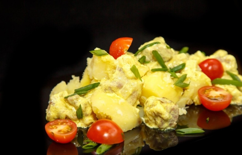 1. Этап. Карри со свининой: С отваренного картофеля слейте воду, добавьте его в сковороду и перемешайте с соусом. Вымойте и нарежьте помидоры черри, нарежьте зелёный лук. Выложите на блюдо картофель с луком, а затем положите помидоры и лук.