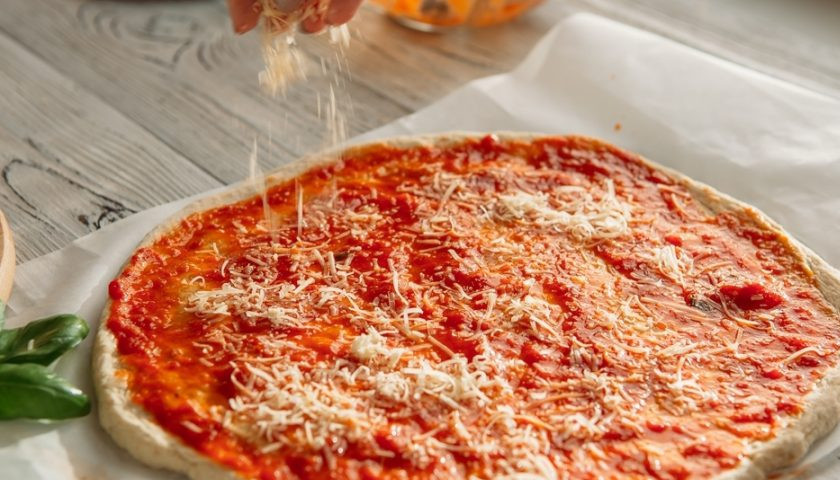 1. Этап. Пицца от Джейми Оливера: Готовое тесто разделите на 2-3 части. Из каждой раскатайте форму для пиццы. Смажьте её томатным соусом и маслом. Сверху натрите пармезан.