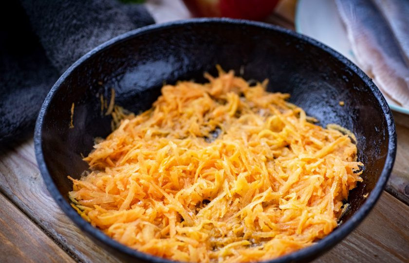 1. Этап. Салат Сельдь под одеялом: В сковороде разогрейте растительное масло и обжарьте до мягкости на небольшом огне морковь. Затем выложите ее в отдельную тарелку охлаждаться.