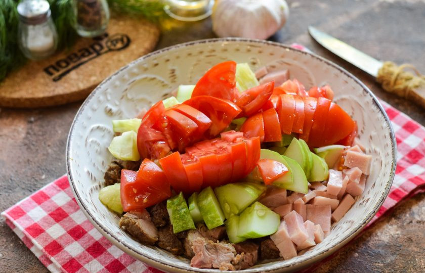 1. Этап. Салат с говядиной и ветчиной: Помидор ополосните и просушите, нарежьте дольками и добавьте в салат.