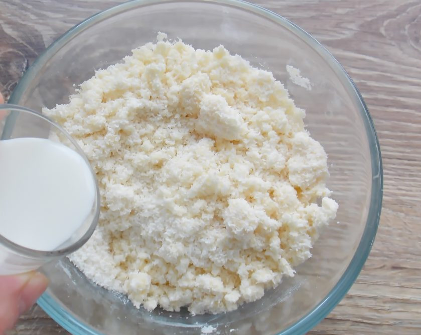 1. Этап. Капкейки Баунти: Порциями влейте сливки до влажной массы, из которой можно слепить комок. Сливок может понадобиться больше или меньше. Все зависит от качества кокосовой стружки.