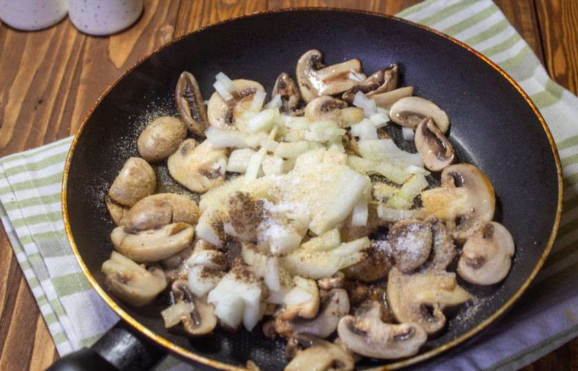 1. Этап. Салат с курицей, грибами и грецким орехом: К грибам добавьте мелко нарезанный лук и готовьте до готовности овощей. Посолите и поперчите. Дайте овощам остыть.