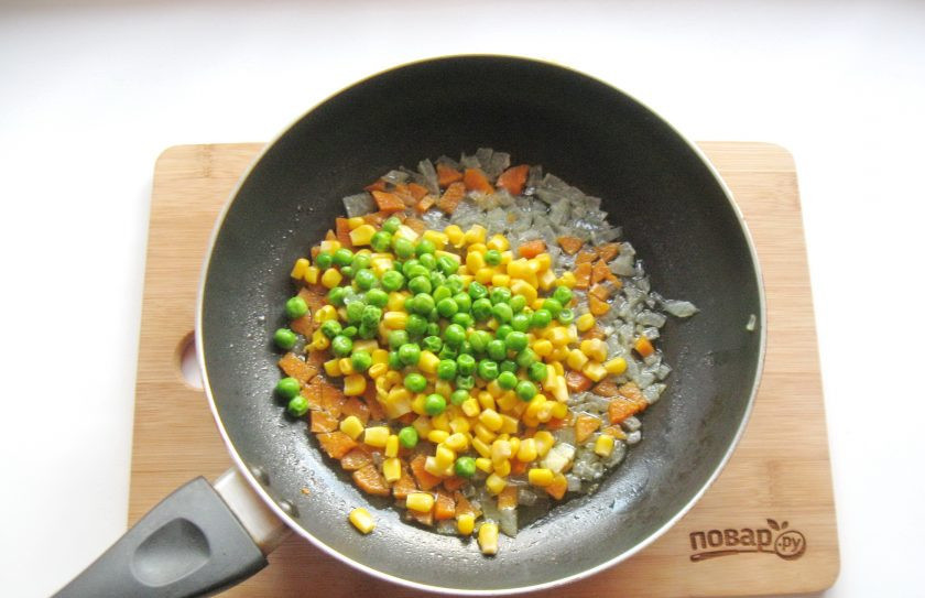 1. Этап. Рис с кукурузой и фасолью: Насыпьте мороженый зеленый горошек.