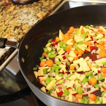 1. Этап. Фаршированная корейка: 5. Нагрейте сковороду, на среднем огне растопите в ней сливочное масло. На масле до золотистого цвета обжарьте нарезанные яблоко, морковь, лук и сельдерей. Это займет минут 5-7.