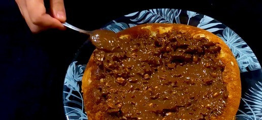 1. Этап. Шоколадно-банановый пирог на сковороде: Растопите плитку шоколада и добавьте оставшийся арахис, хорошо перемешайте. С помощью лопатки распределите шоколадную смесь по верхушке торта.