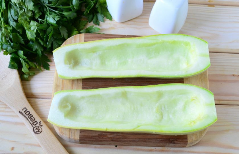 1. Этап. Кабачки, фаршированные куриной грудкой: Кабачок разрежьте пополам вдоль, чайной ложкой удалите мякоть, чтобы получилась лодочка. Но слишком много мякоти не вынимайте, стенки должны получиться толщиной около 7-9 мм. Положите лодочки из кабачка в духовку и запекайте при 180 градусах 15-20 минут, как раз пока будет готовиться начинка.