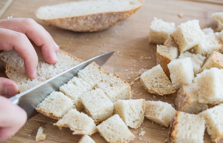 1. Этап. Сухарики для Цезаря: 1. Первым делом включите духовку и пусть разогревается до 180-190 градусов. Нарежьте батон или хлеб небольшими кубиками. В некоторых вариантах хлеб на сухарики ломают руками на небольшие кусочки произвольной формы.