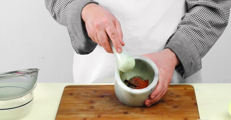 1. Этап. Бараньи ребрышки на гриле: Пока баранина маринуется в холодильнике, приготовьте для нее смесь специй. Для этого в ступке растолките зиру, кориандр, гвоздику, корицу, черный перец горошком, добавьте щепотку красного молотого перца.