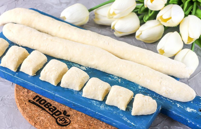 1. Этап. Ленивые вареники в мультиварке: Нарежьте каждую колбаску теста порционными кусочками по 1,5-2 см. толщиной. На этом этапе вы можете заморозить заготовки на досочке, чтобы иметь под рукой полуфабрикаты.