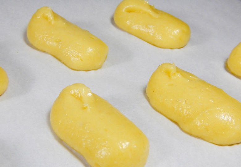 1. Этап. Пирожные Эклер: 13. Выложите в кондитерский мешок тесто и отсадите эклеры на противень с пергаментом.