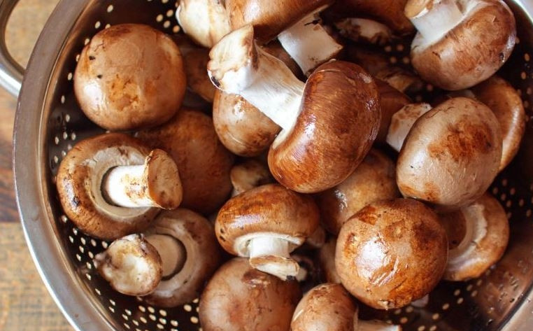 1. Этап. Шампиньоны на гриле на мангале: Грибы выложите в миску и залейте их холодной водой. Тщательно вымойте шампиньоны в воде, затем слейте ее, грибы почистите и промойте еще раз под проточной водой.