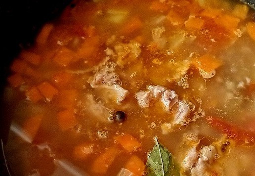 1. Этап. Гречневый суп с тушёнкой Походный: Всё у нас в казане сварилось. Заправляем суп тушёнкой. Её нужно измельчить в банке на небольшие кусочки, прежде чем выкладывать в казан. Положим лавровый лист. Через пару минут снимаем с огня казан. Даём настояться немного под крышкой.