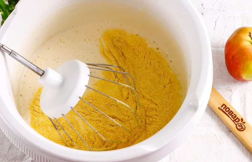1. Этап. Шарлотка из кукурузной муки: Во взбитую яичную массу вмешайте кукурузную муку аккуратными движениями, но не с помощью техники, чтобы не выпустить пузырьки воздуха.