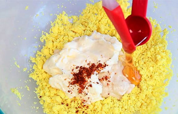 1. Этап. Яйца с пряностями II: Желтки разомните вилкой, добавьте майонез, хрен, перец и мед.