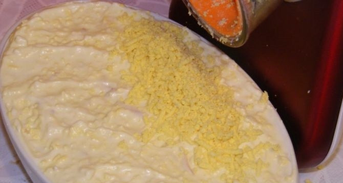 1. Этап. Салат Крабы в шубе: 10. На крабовые палочки выкладываю тертое яблоко, снова поливаю немного майонезом. В качестве украшения отварные желтки измельчаю на мелкой терке, посыпаю ими салат.