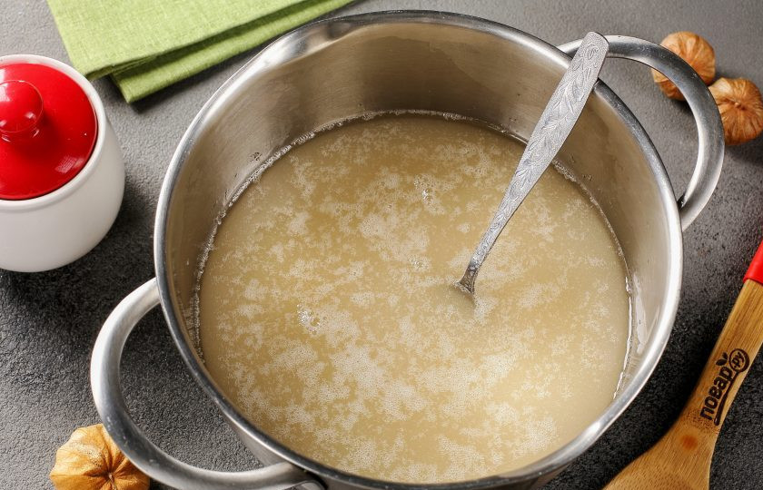 1. Этап. Цукаты из физалиса: Соедините воду и сахар. Поставьте на небольшой огонь и помешивая, дайте сахару раствориться.