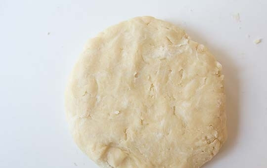 1. Этап. Заливной пирог с лососем: 2. Понемногу влейте воду, чтобы сформировалось тесто. Оберните его в пленку и отправьте в холодильник на 1-2 часа.