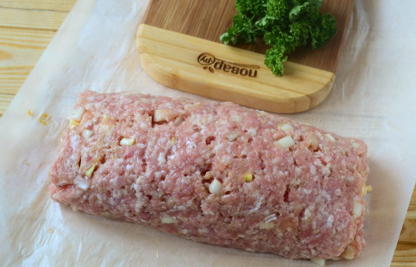 1. Этап. Сытные фрикаделины с начинкой: Заверните фарш с сыром в рулет, помогая себе пергаментом.