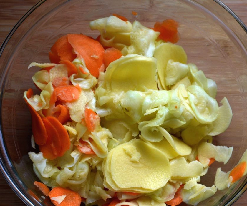 1. Этап. Запеканка-кугель из овощей с индейкой: Морковь, картофель и кабачок помойте, очистите и тоненько нарежьте. Выложите овощи в глубокую миску.