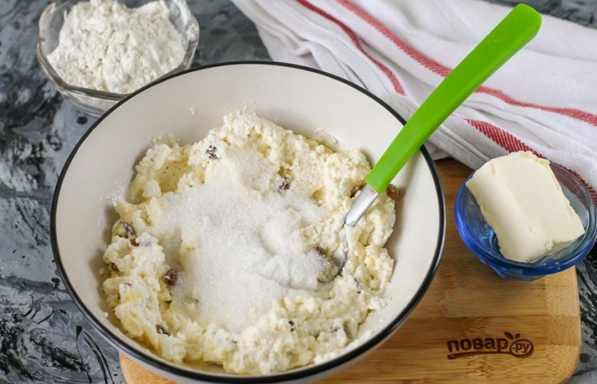 1. Этап. Сырники из кислого творога: Всыпьте сахарный песок и тщательно перемешайте всю массу.