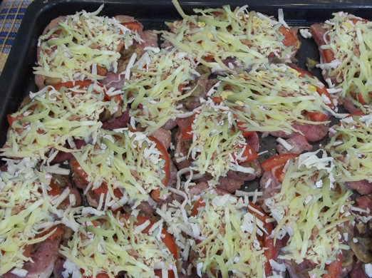 1. Этап. Французские отбивные из свинины в духовке: 13. Посыпаю свинину сперва плавленым, а потом уже твердым сыром и отправляю в духовку.