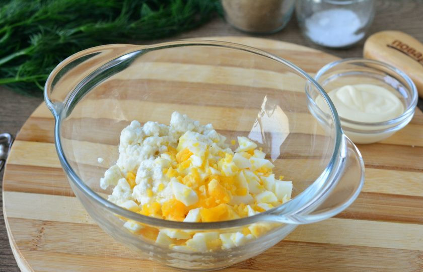 1. Этап. Крабовые палочки фаршированные творогом: Сварите куриные яйца вкрутую, остудите, почистите и нарежьте мелкими кубиками. Смешайте яйца и творог.