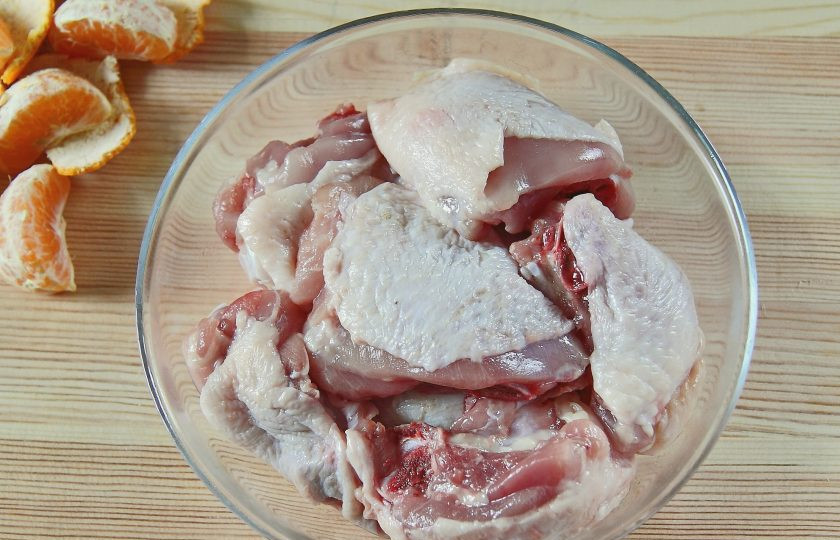 1. Этап. Курица в мандаринах: Порубите курицу на части и сложите в глубокую миску или тарелку.