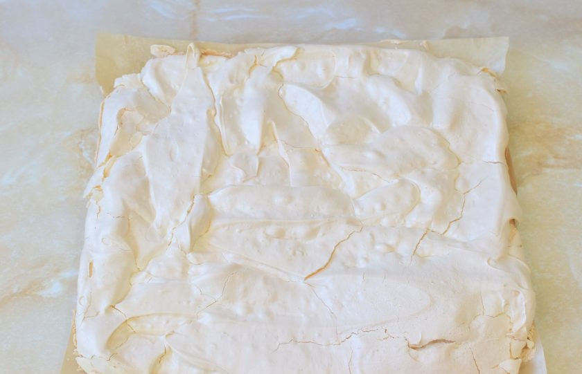 1. Этап. Меренговый рулет с заварным кремом: Готовая меренга внутри остается мягкая и воздушная, а снаружи появляется тонкая хрустящая корочка. Извлеките её из духовки и остудите. Затем переверните на лист пергамента, а тефлоновый коврик снимите.