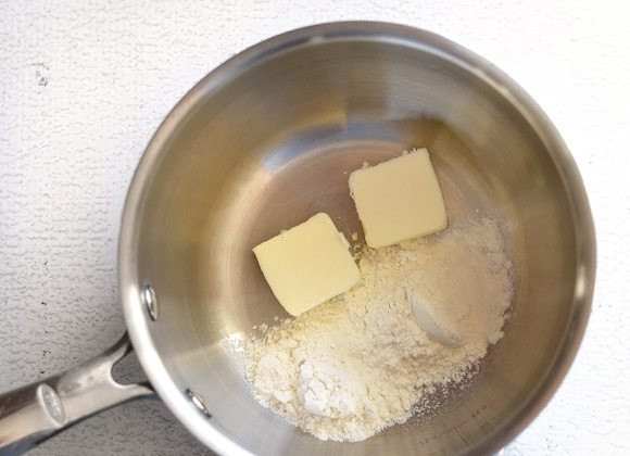 1. Этап. Сырный соус за 5 минут: 1. В сотейник насыпьте муку и выложите сливочное масло.