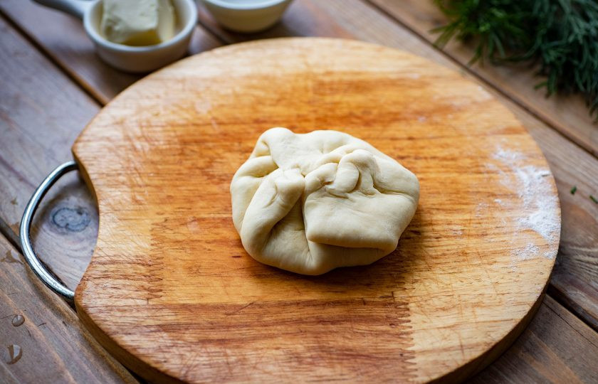 1. Этап. Хачапури на молоке с сыром: Защепите края теста вверху, формируя мешочек из теста с начинкой внутри.